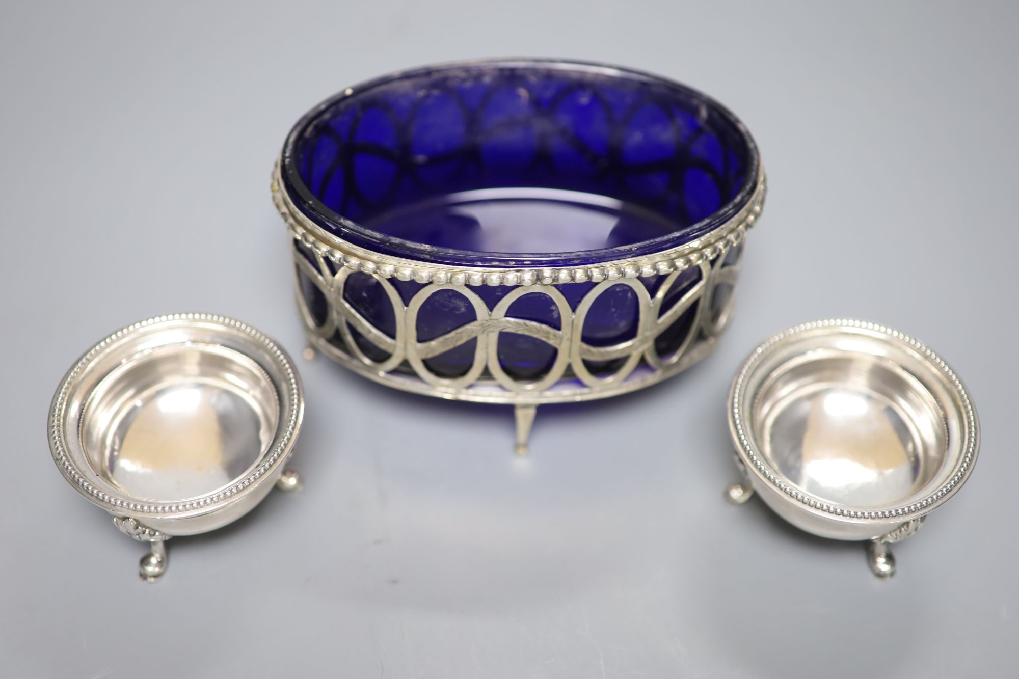 An 18th/19th century Continental silver beaded openwork oval table salt cellar with blue glass liner and a pair of cauldron salts